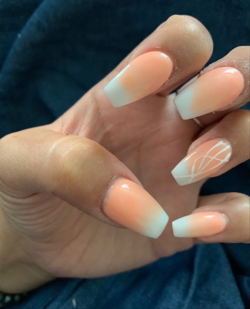 Nail technician shaping acrylic nails at a salon station.